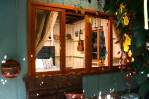 um espelho no lado de um quarto com uma guitarra em Casa Curativa em Tzununá