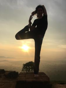 a woman doing yoga on top of a mountain at Little wood villa Doluwa in Kandy