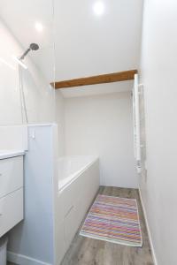 ein weißes Bad mit einer Badewanne und einer Dusche in der Unterkunft Charmant tout confort, T3 Hypercentre Vienne in Vienne