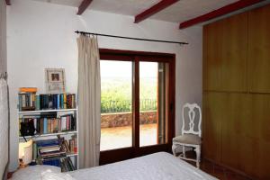 ein Schlafzimmer mit einem Bett und einem Bücherregal mit einem Fenster in der Unterkunft Villa Le Saline Ampia Vista Mare in Palau