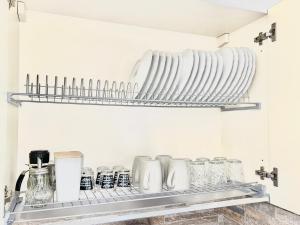 una mensola con piatti e bicchieri in cucina di Dolce Vita Sperlonga a Sperlonga