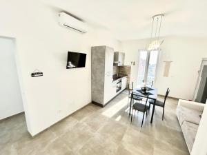 a living room with a table and a kitchen at DOLCE VITA Sperlonga - UN LETTO IDEALE in Sperlonga +25 photos