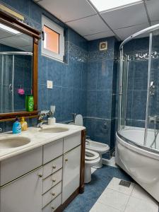 a bathroom with a sink and a tub and a toilet at My Mother's House Hostel in Skopje