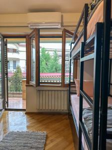 Zimmer mit Etagenbetten und einem großen Fenster in der Unterkunft My Mother's House Hostel in Skopje