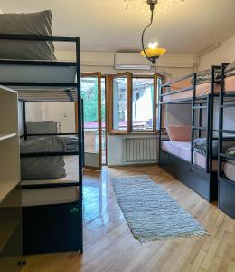 a room with bunk beds and a rug at My Mother's House Hostel in Skopje