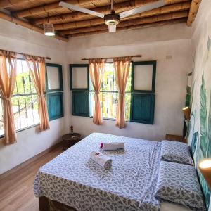 a bedroom with a bed in a room with windows at CHEVERE BEACH CABAÑAS SAS in Puebloviejo