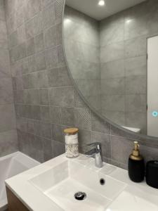 ein Bad mit einem Waschbecken und einem Spiegel in der Unterkunft 3 pièces neuf au pied des musées - Wifi & Parking in Grasse