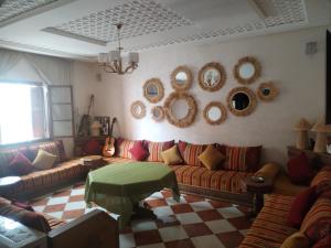 - un salon avec des canapés et des miroirs sur le mur dans l'établissement DAR SARSAR airport, à Marrakech