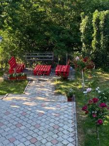 a group of red chairs and flowers in a garden at Ljiljin raj in Bela Zemlja