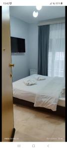een slaapkamer met een bed met witte lakens en een raam bij Umbrella Apartment in Perea