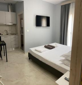 een slaapkamer met een bed en een tv aan de muur bij Umbrella Apartment in Perea