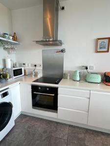 uma cozinha com armários brancos e um forno com placa de fogão em 湖景度假屋Lakeview Vacation Home em Belturbet