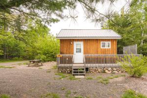 a wooden cabin with a bench and a picnic table at Cabot Shores in Indian Brook