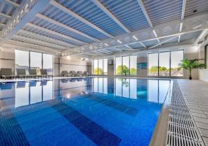 a large swimming pool with blue water at Last Drop Village Hotel & Spa in Bolton