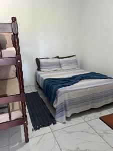 1 dormitorio con 1 cama y 1 silla en Recanto Monte Trigo, en São Francisco do Sul