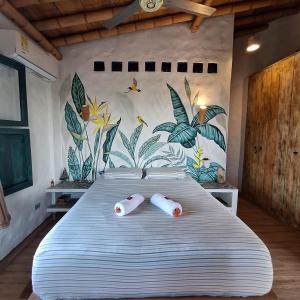 a bedroom with a large bed with two pillows on it at CHEVERE BEACH CABAÑAS SAS in Puebloviejo