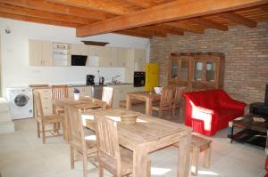a kitchen with wooden tables and chairs and a red chair at Likaskalács in Regöly