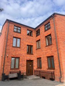 a red brick building with a bench in front of it at Apartamenty na Maja - 6 in Skierniewice
