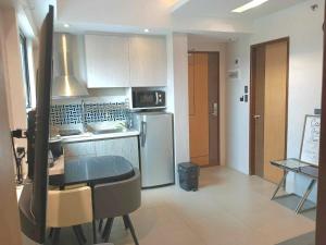 a kitchen with a refrigerator and a table in it at Bel's 2 Bedroom Condo in Santorini Hotel Sta. Lucia Mall Cainta Rizal in Manila