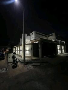 um edifício iluminado com uma luz de rua à noite em Élégante villa avec cour privée em Lomé
