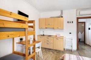 een kamer met een stapelbed en een keuken met een bureau bij Alpen Pila Residence Loft 2 in Aosta