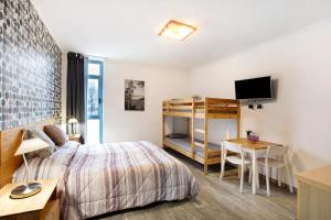 een slaapkamer met een bed, een bureau en een televisie bij Alpen Pila Residence Loft 2 in Aosta