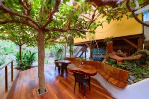 un patio con mesas y sillas bajo un árbol en Cabinas Montesol en Puerto Viejo