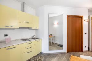 a kitchen with white cabinets and a wooden door at Alpen Pila Residence Loft 5 in Aosta +22 photos
