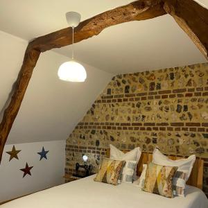 Ce lit se trouve dans une chambre dotée d'un mur en briques. dans l'établissement Ecolodge ENTRE MER & CAMPAGNE - Maison d'Hôtes POMME DE PAILLE - Entre Honfleur et Etretat, à Octeville-sur-Mer