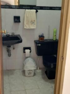 baño con aseo negro y lavamanos en CYM RICAURTE, en Ricaurte