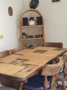 una mesa de madera en una habitación con sillas y un estante en CYM RICAURTE, en Ricaurte