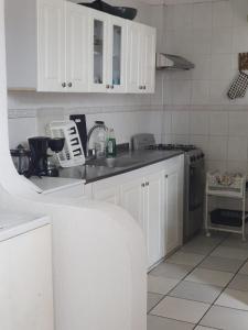 cocina con armarios blancos y encimera en CYM RICAURTE, en Ricaurte