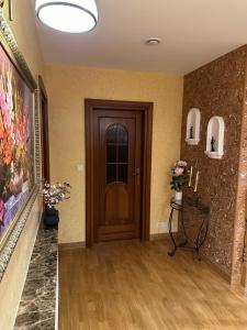 un couloir avec une porte en bois et un tableau dans l'établissement Villa Sophie, à Żabno