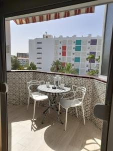 Un patio con una mesa y sillas en un balcón. en Casa Lola, en Maspalomas