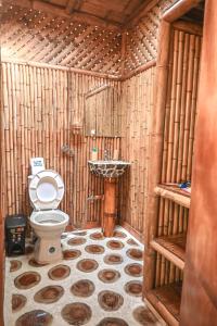 a bathroom with a toilet in a wooden structure at Sikeo Eco Glamping in Icononzo