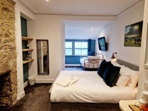 ein Schlafzimmer mit einem weißen Bett und einem Kamin in der Unterkunft Wheal Tor Hotel & Glamping in Liskeard