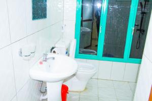 ein Badezimmer mit einem WC, einem Waschbecken und einem Spiegel in der Unterkunft Branice Guest House in Kigali