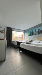 a large room with two beds and a large window at Hotel Gran Conquistador 33 in Medellín