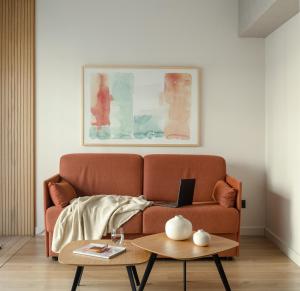 Apartamentos Líbere Bilbao Museo في بلباو: غرفة معيشة مع أريكة وطاولة