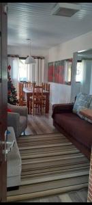 sala de estar con sofá y comedor en Casa Amarela próximo ao mar com mesa de Sinuca, 100 mts - 2 km do centro, en Arroio do Silva