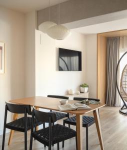 Apartamentos Líbere Bilbao Museo في بلباو: غرفة طعام مع طاولة وكراسي خشبية