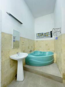 a bathroom with a sink and a bath tub at ADORA Home Bandung chill & cozy in Bandung