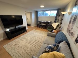 a living room with a couch and a flat screen tv at Renovated 2 Bedroom Suite w/ King Bed in Kamloops