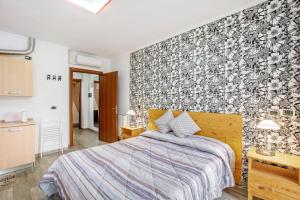 um quarto com uma cama com uma parede floral em Alpen Pila Residence Loft 1 em Aosta