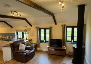 a living room with a couch and a stove at Maple & Beech Barns in Truro