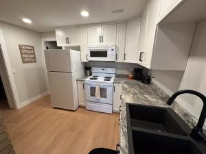 a kitchen with white cabinets and a stove and microwave at Renovated 2 Bedroom Suite w/ King Bed in Kamloops