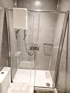 y baño con ducha y puerta de cristal. en Wheal Tor Hotel & Glamping, en Liskeard