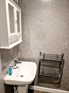 y baño con lavabo blanco y espejo. en Wheal Tor Hotel & Glamping en Liskeard