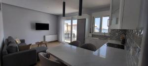 a kitchen and living room with a table and chairs at Beachfront Bliss in Kardamaina