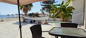 uma mesa e cadeiras e uma rede de descanso numa praia em Beachfront Bliss em Kardamaina